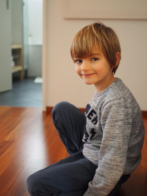 Ritratto di un ragazzo sorridente seduto a casa