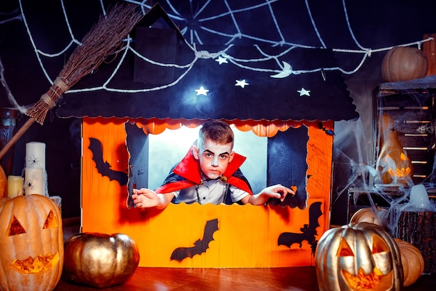 Ritratto di un ragazzo vestito con un costume di un vampiro su sfondo grunge. Festa di Halloween.