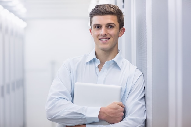 Ritratto di un tecnico sorridente che tiene un computer portatile