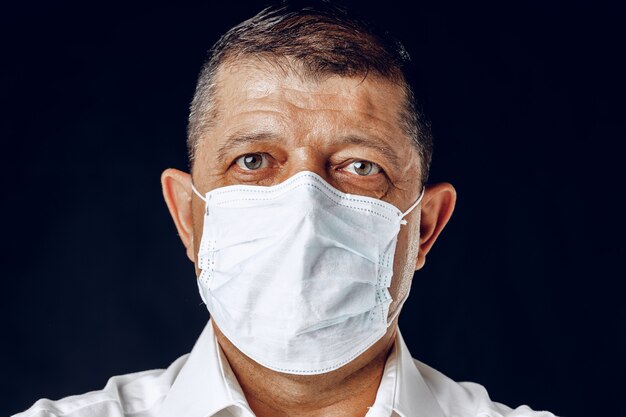 Ritratto di un uomo adulto malato nella mascherina medica si chiuda. Concetto di pandemia di coronavirus