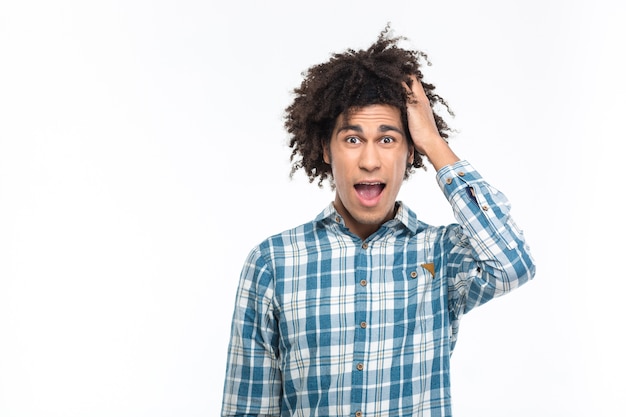 Ritratto di un uomo afroamericano stupito con i capelli ricci che sembra isolato su un muro bianco