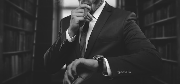 Ritratto di un uomo alla moda in un vestito con un sigaro. Concetto di affari. Tecnica mista