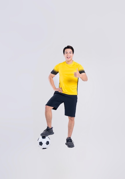 Ritratto di un uomo asiatico che gioca a calcio su sfondo bianco