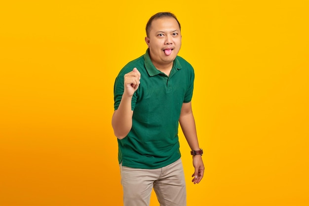 Ritratto di un uomo asiatico che mostra il gesto della mano piegando le dita davanti alla telecamera con un'espressione divertente