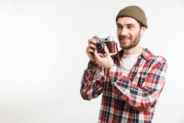 Ritratto di un uomo barbuto felice in camicia a quadri che prende una foto