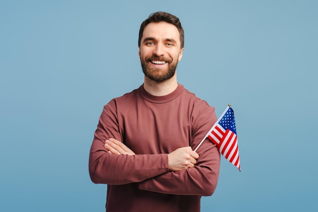 Ritratto di un uomo bello e attraente che indossa abiti casuali eleganti con la bandiera americana