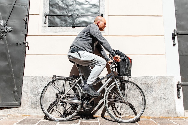 Ritratto di un uomo bello hipster Un uomo in una città in bicicletta lungo la strada in bicicletta uno stile di vita