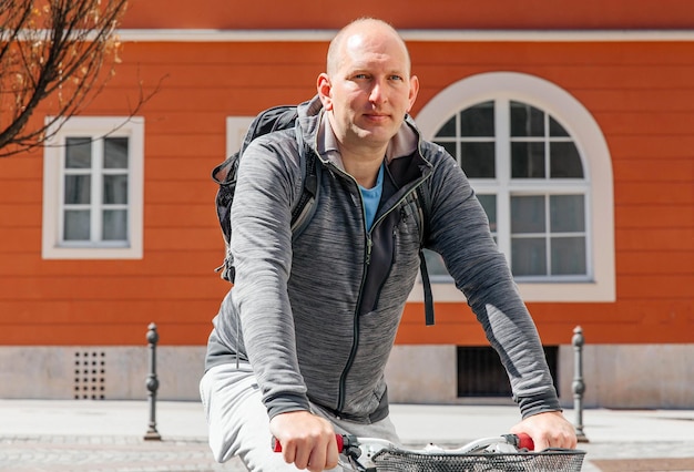 Ritratto di un uomo bello hipster Un uomo in una città in bicicletta lungo la strada in bicicletta uno stile di vita