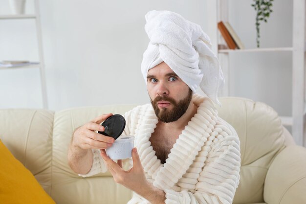 Ritratto di un uomo che applica una crema efficace sulla spa della pelle del viso a casa per il corpo e la cura della pelle per gli uomini