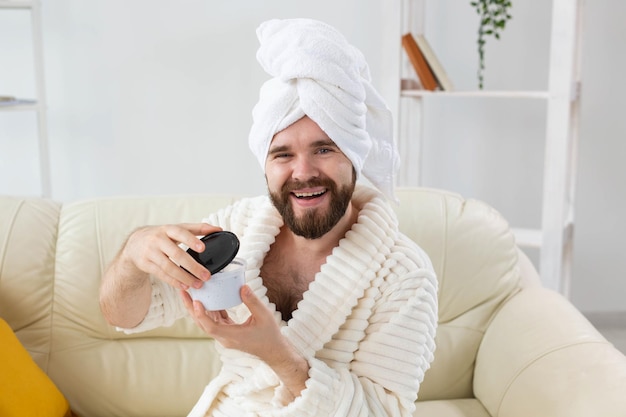 Ritratto di un uomo che applica una crema efficace sulla spa della pelle del viso a casa per il corpo e la cura della pelle per gli uomini