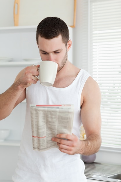 Ritratto di un uomo che beve il tè durante la lettura delle notizie