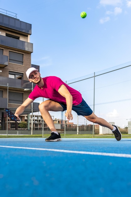 Ritratto di un uomo che gioca a pickleball Immagine di un giocatore di pickleball che corre e si allunga per colpire la palla durante una partita