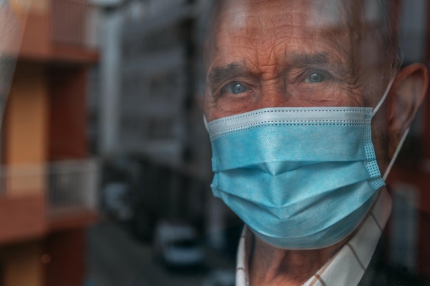 Ritratto di un uomo che indossa una maschera che guarda attraverso la finestra