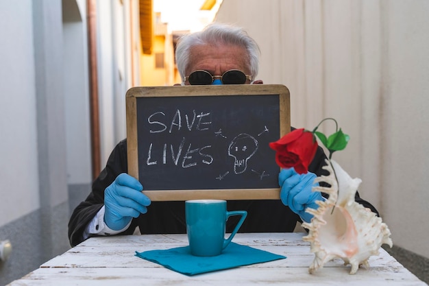 Ritratto di un uomo che tiene un'ardo con il testo "Salva vite"