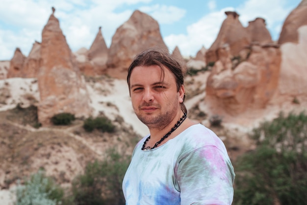 Ritratto di un uomo con i capelli lunghi sullo sfondo del rilievo della Cappadocia