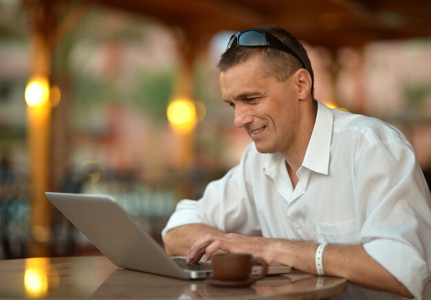 Ritratto di un uomo con laptop sul tavolo