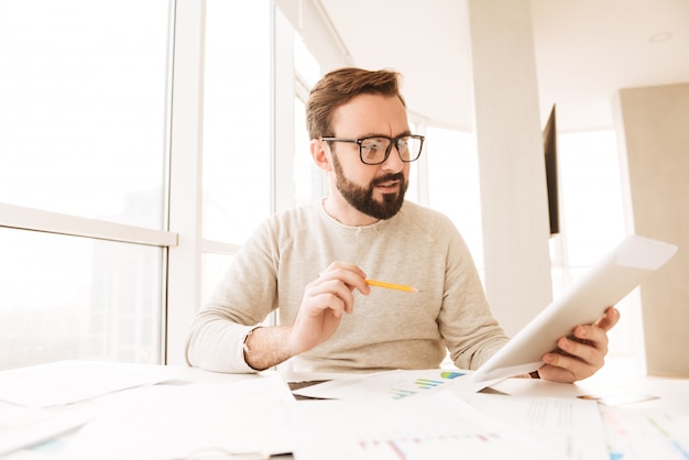 Ritratto di un uomo concentrato che lavora con i documenti