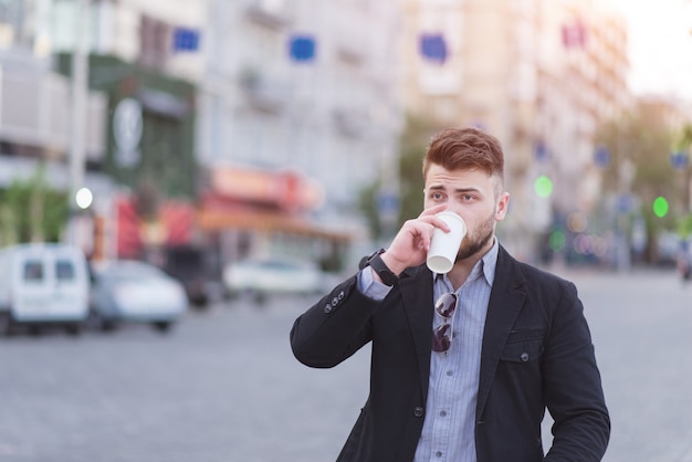 Ritratto di un uomo d'affari bello bere caffè