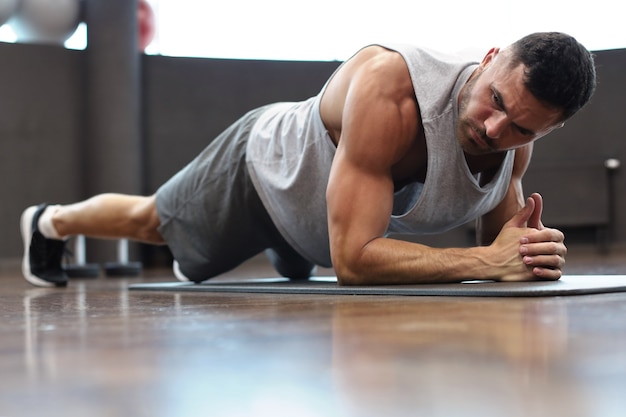 Ritratto di un uomo di forma fisica che fa esercizio di fasciame in palestra.