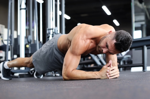 Ritratto di un uomo di forma fisica che fa esercizio di fasciame in palestra.