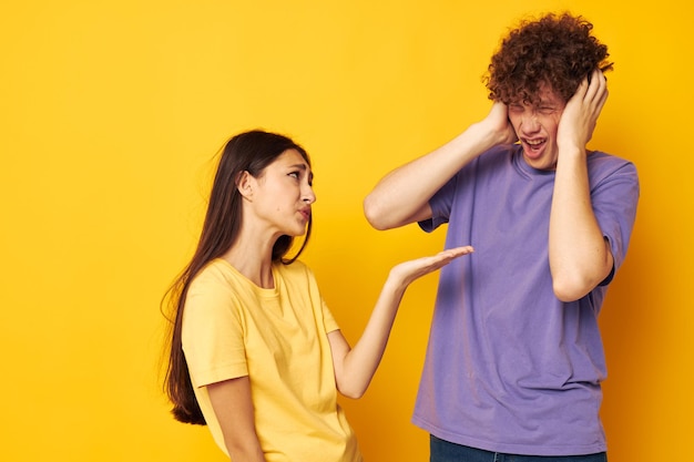 Ritratto di un uomo e di una donna amicizia in posa divertente studio sfondo giallo inalterato