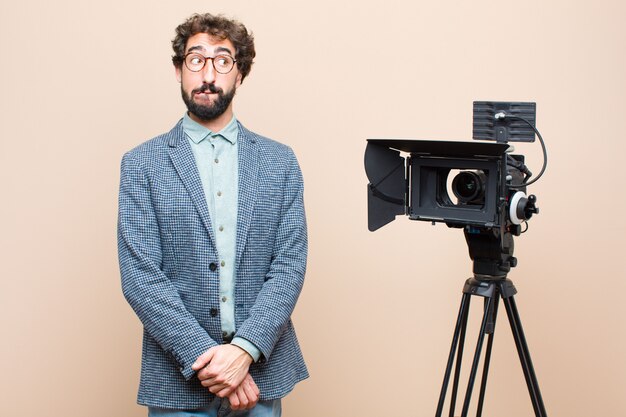 ritratto di un uomo e la sua macchina fotografica su uno sfondo color crema