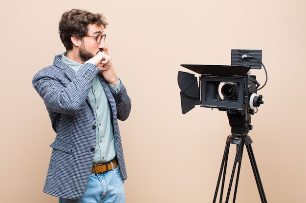 ritratto di un uomo e la sua macchina fotografica su uno sfondo color crema