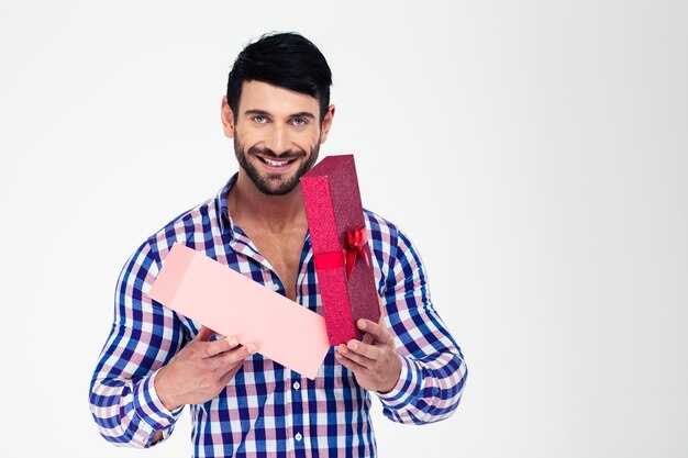 Ritratto di un uomo felice apertura confezione regalo isolato su un muro bianco