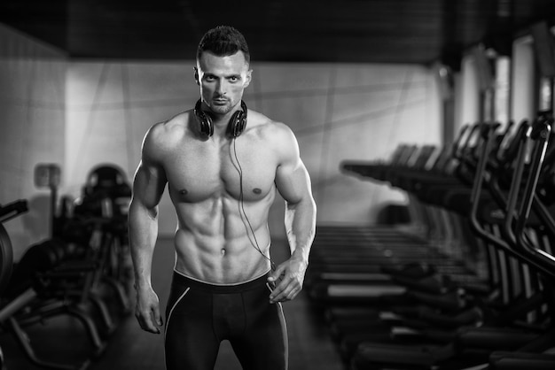 Ritratto di un uomo fisicamente in forma in posa nella moderna palestra del centro fitness
