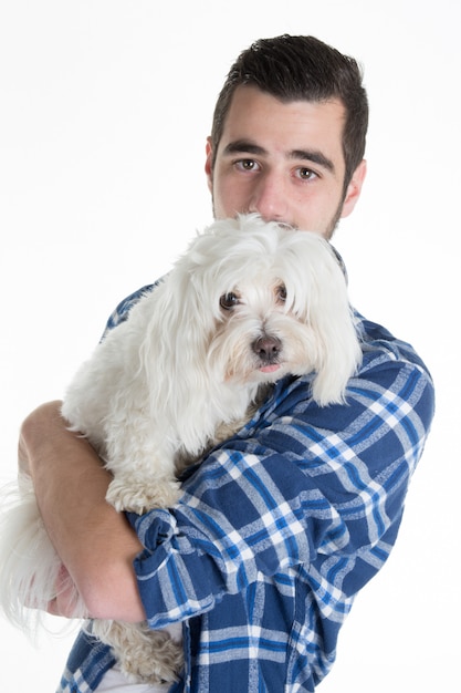 Ritratto di un uomo in possesso di un cane bianco Maltese bischon isolato su bianco.