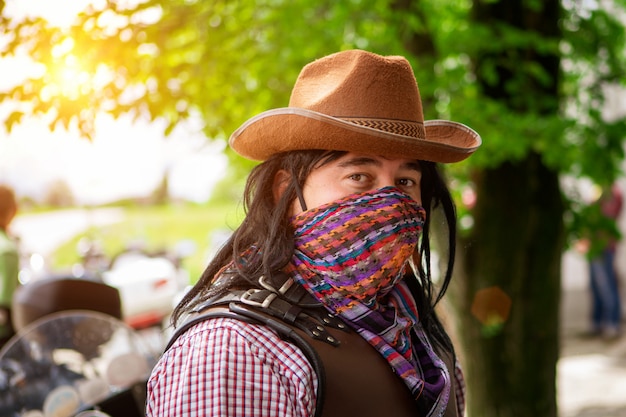 Ritratto di un uomo in un cappello da cowboy e una sciarpa faccia coperta