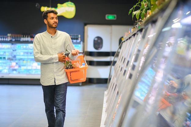 ritratto di un uomo indiano in un negozio di alimentari con un atteggiamento positivo