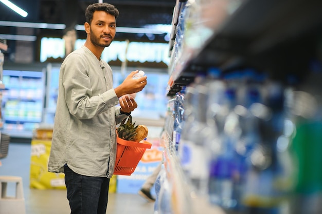 ritratto di un uomo indiano in un negozio di alimentari con un atteggiamento positivo