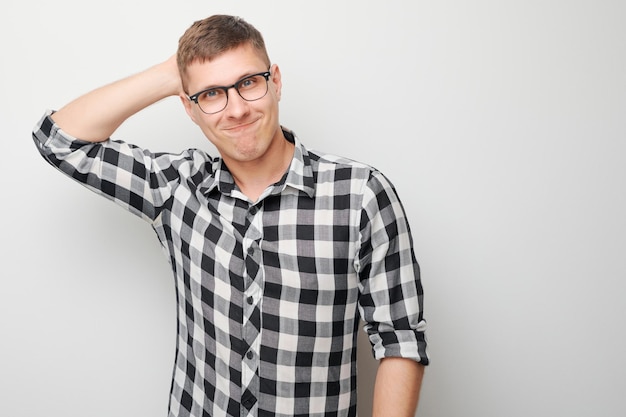 Ritratto di un uomo intelligente in camicia che tocca la testa pensa dubbi sceglie isolato su sfondo bianco di studio con spazio di copia