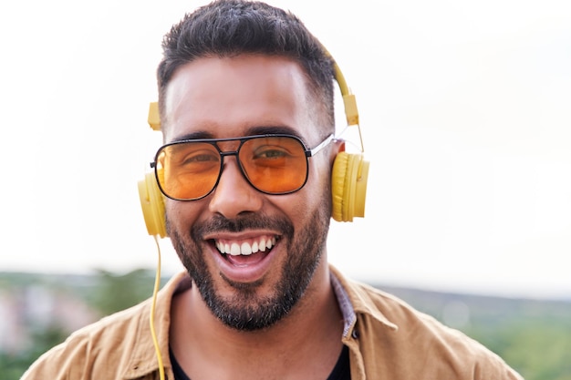 Ritratto di un uomo latino sorridente che ascolta la musica