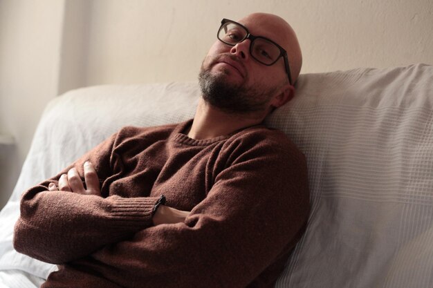 Ritratto di un uomo riflessivo che si rilassa a letto a casa