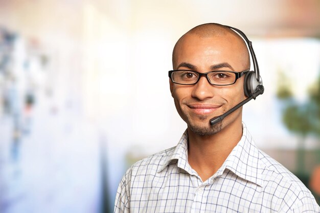 Ritratto di un uomo sorridente con auricolare che lavora come operatore di call center