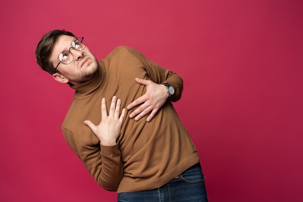 Ritratto di un uomo spaventato isolato su sfondo rosa alla moda.