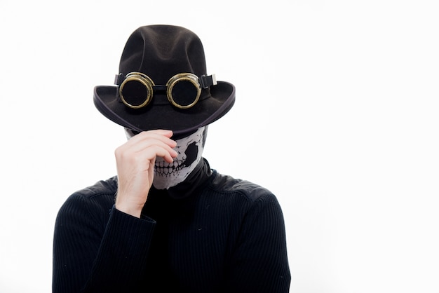 Ritratto di un uomo steampunk con lo scheletro di cappello e maschera isolato