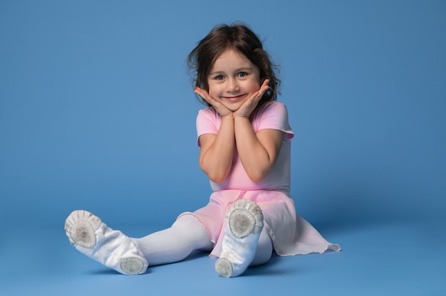 Ritratto di una ballerina adorabile della ragazza del bambino che sorride sveglio mentre sedendosi