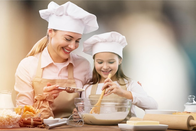 Ritratto di una bambina adorabile e di sua madre che cucinano insieme