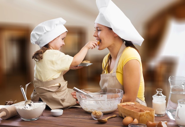 Ritratto di una bambina adorabile e di sua madre che cucinano insieme