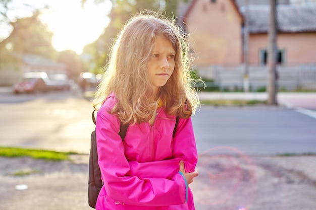 Ritratto di una bambina arrabbiata di 9 anni in una città soleggiata.