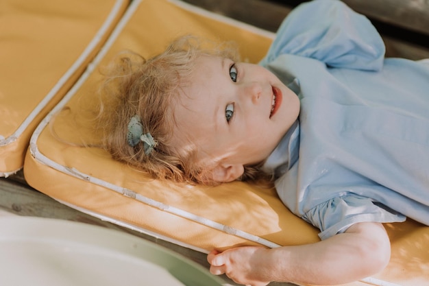 ritratto di una bambina bionda carina con un cappello di paglia e un vestito blu