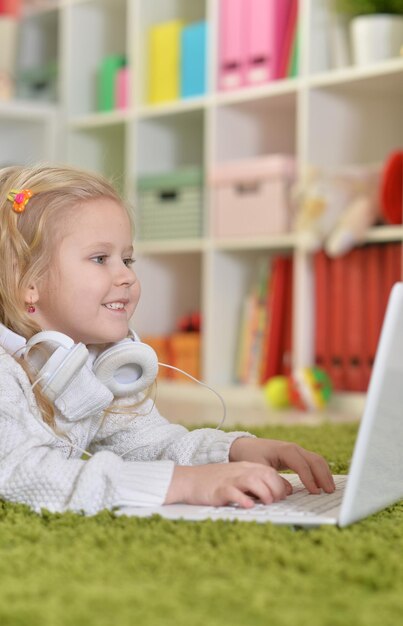 Ritratto di una bambina carina che usa il laptop