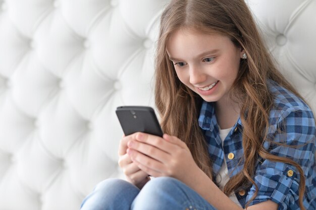 Ritratto di una bambina carina che utilizza uno smartphone moderno