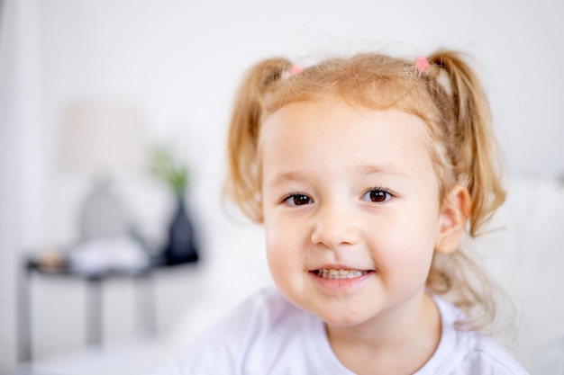 Ritratto di una bambina carina con i capelli bianchi il volto di un bambino biondo sorridente