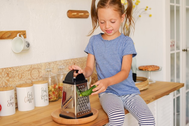 ritratto di una bambina carina in cucina con generi alimentari e cibo sano