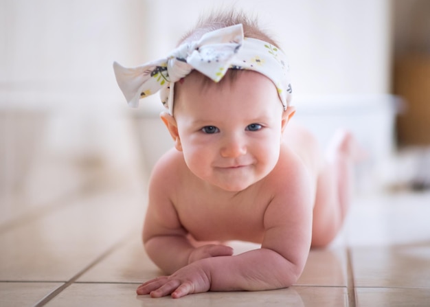 Ritratto di una bambina carina sdraiata sul pavimento di piastrelle