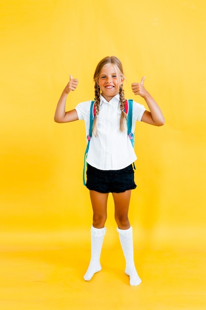 Ritratto di una bambina carina su sfondo giallo.